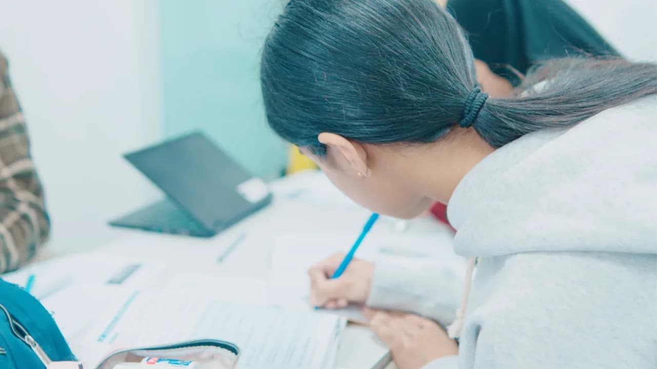 A pupil completing a timed 11+ practice paper