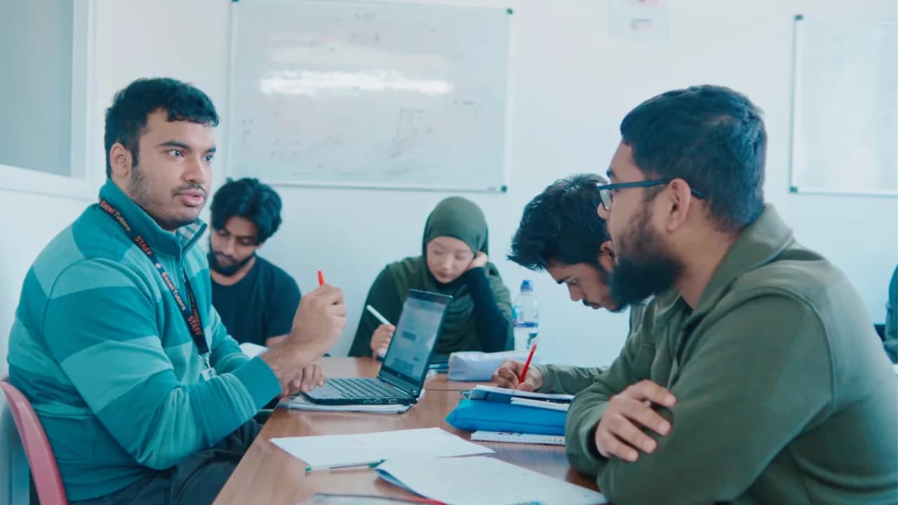 An Excel Tutors tutor supporting students one-to-one in a small group